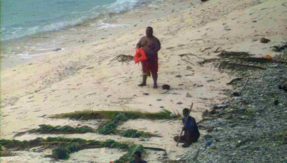 Grâce à leur HELP géant sur le sable trois naufragés secourus sur une île déserte du Pacifique
